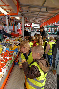 Kinder an einem Gemüsestand auf dem Markt