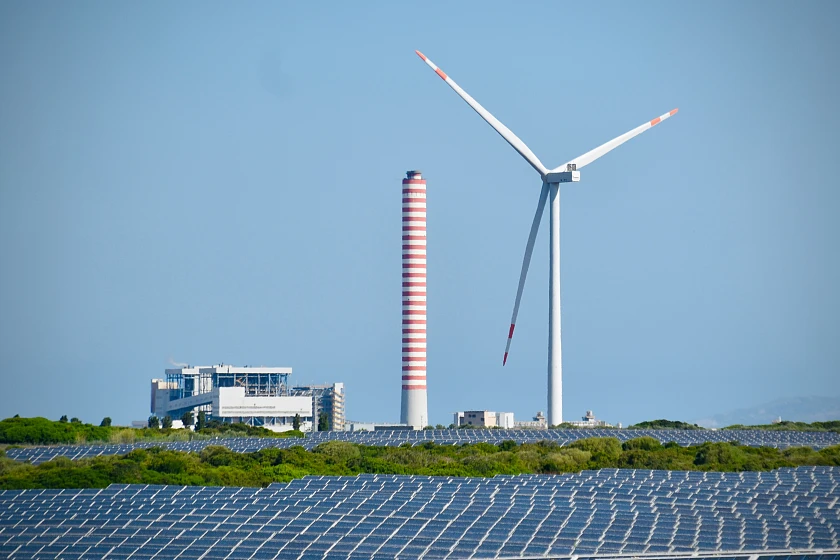 Eine Windkraftanlage steht hinter einem Photovoltaikanlage und verdeutlicht die Bedeutung regenerativer Energiegewinnung für die Regionalwirtschaft.