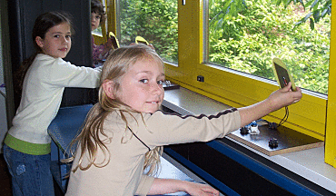 Mehrere Schülerinnen messen die Helligkeit in ihrem Klassenraum.